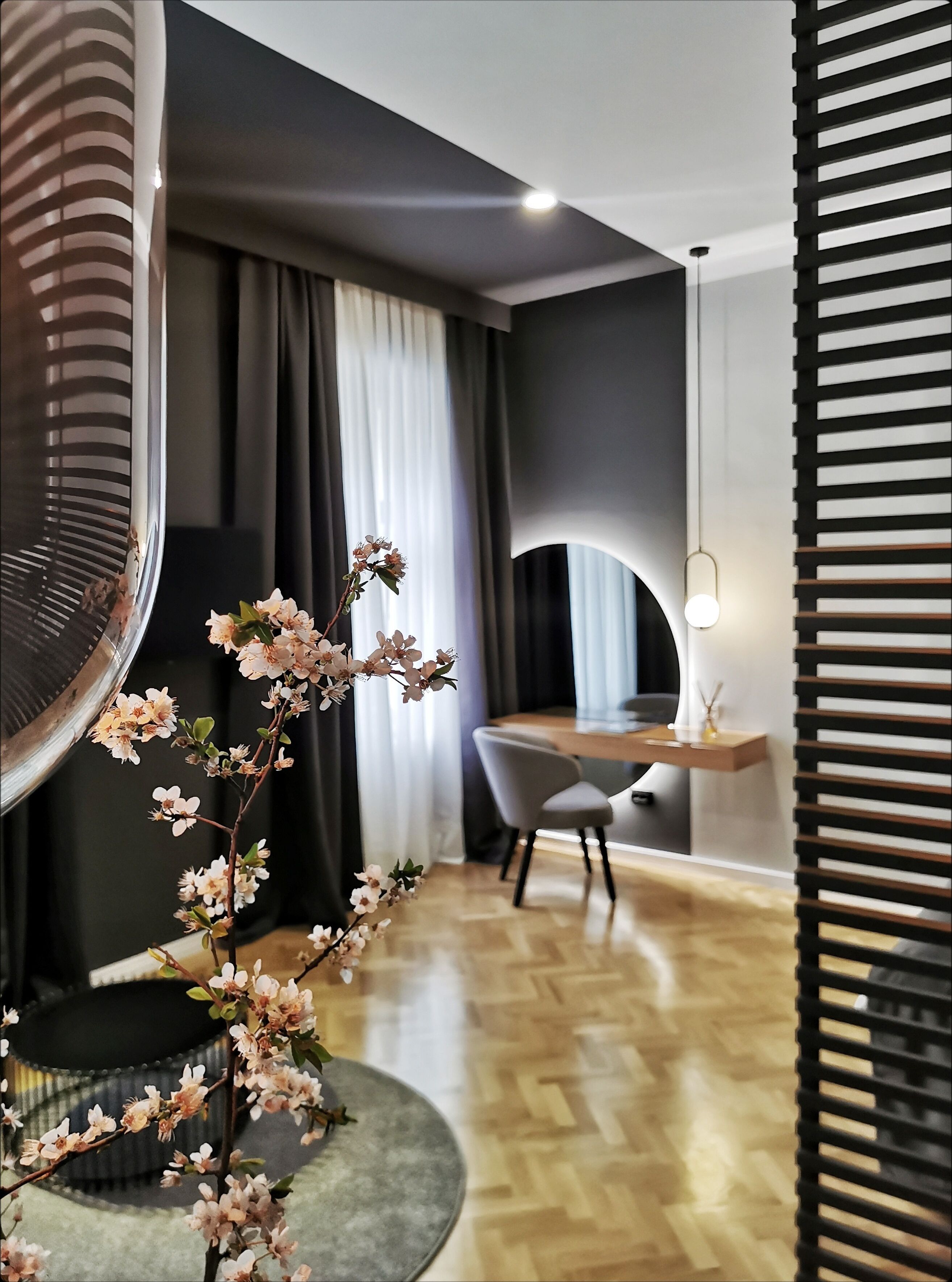 A modern interior with a dining area, a large fan, and a decorative plant.