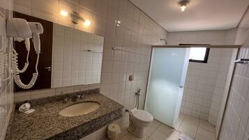 Un baño moderno con lavamanos de granito, inodoro blanco y cabina de ducha de vidrio.