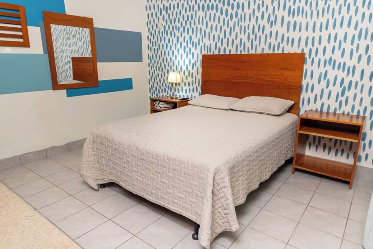 A neatly arranged bedroom with a bed, a nightstand, and a bedside table.