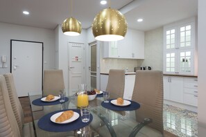 Enjoy meals with friends and family in this stylish dining area, featuring a glass-top table and comfortable seating for four.