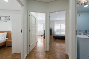 Relax in a spacious room with a large bed, desk, and bathroom featuring a sink and mirror.