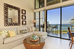 Relax in a spacious living area with a comfortable sofa, round coffee table, and large mirror.