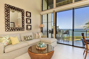 Relax in a spacious living area with a comfortable sofa, round coffee table, and large mirror.