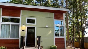 A two-story building with a green facade and red siding. - Upscale Modern Private Cottage (Kirkland)
