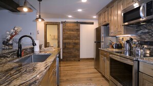Una cocina moderna con armarios de madera, electrodomésticos de acero inoxidable y encimera de granito.