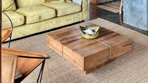 A living room with a sofa, coffee table, and a staircase. - Casa  Rosa Chá  Pico (Açores - Ilha do Pico)
