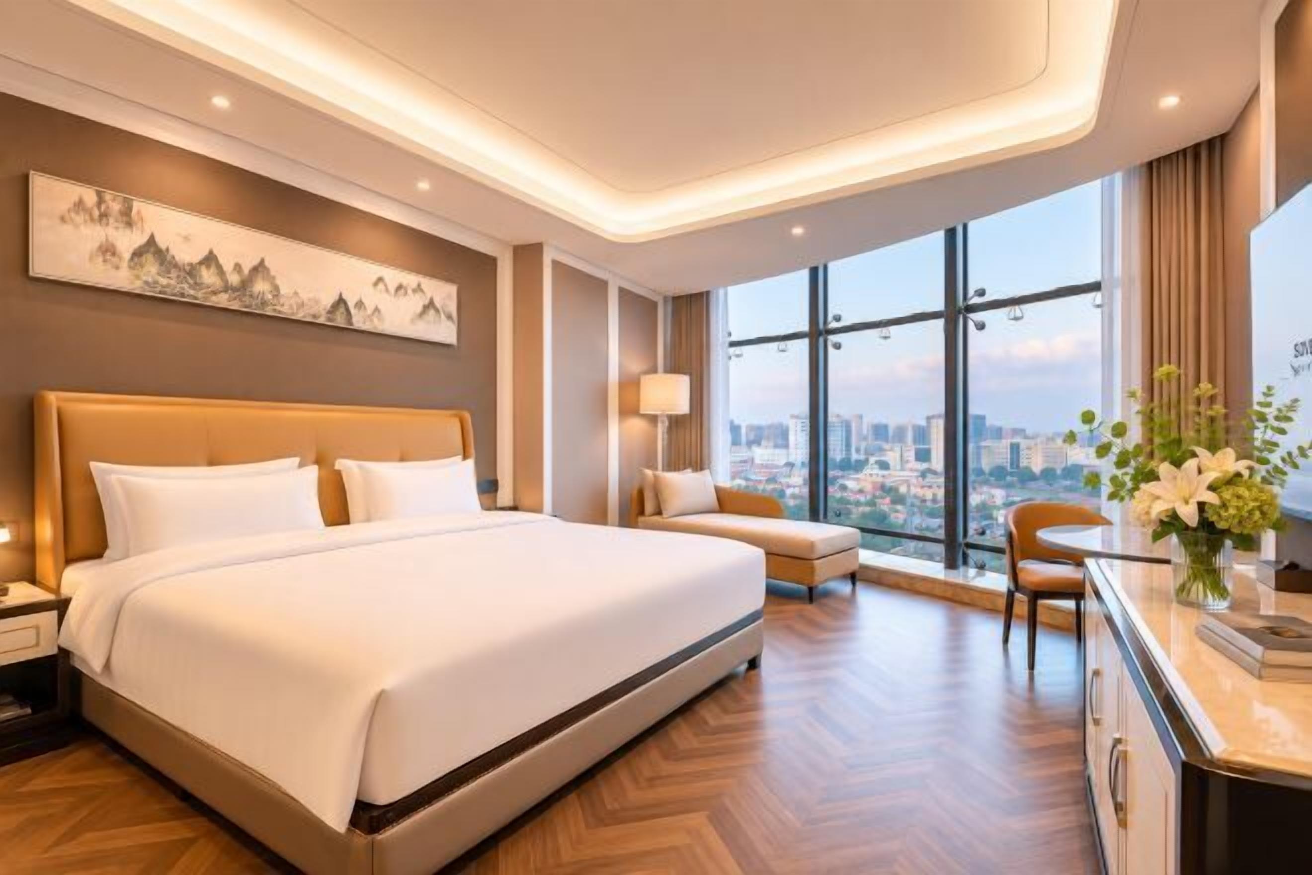 Una habitación de hotel moderna con una cama grande, una zona de estar, un escritorio y vista a la ciudad.