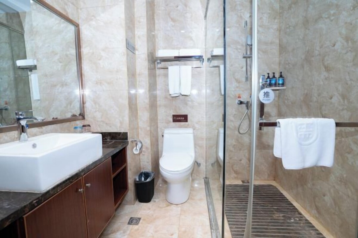 A modern bathroom with a sink, toilet, and shower area.