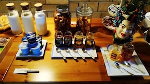 Et bord med krukker med krydderier, en tallerken med småkager og en dekorativ hovedskulptur.