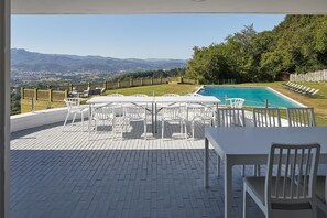 A poolside area with white outdoor furniture, a view of a mountain range, and a fenced garden. - BASQUE BREATH - One-of-a-kind villa, fantastic view, fabulous pool (hondarribia)