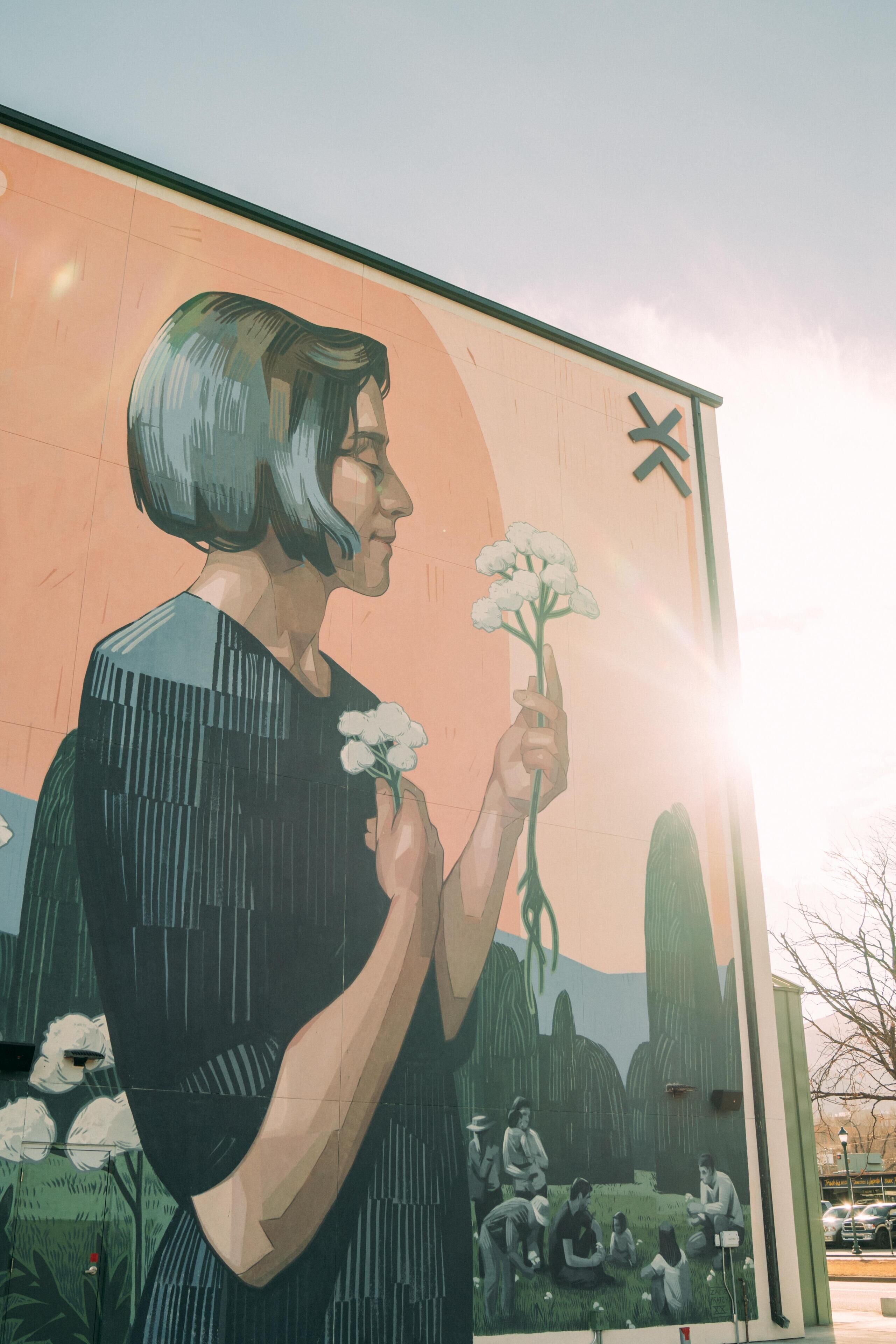 Un mural que muestra a una persona sosteniendo una flor.