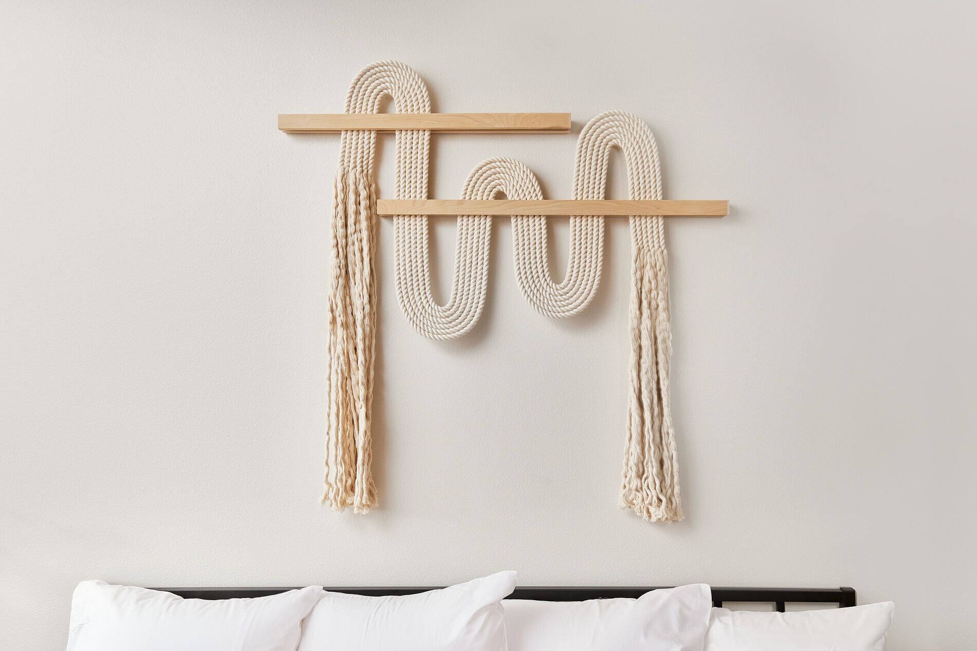 Una cama con ropa de cama blanca y un cabecero de madera.