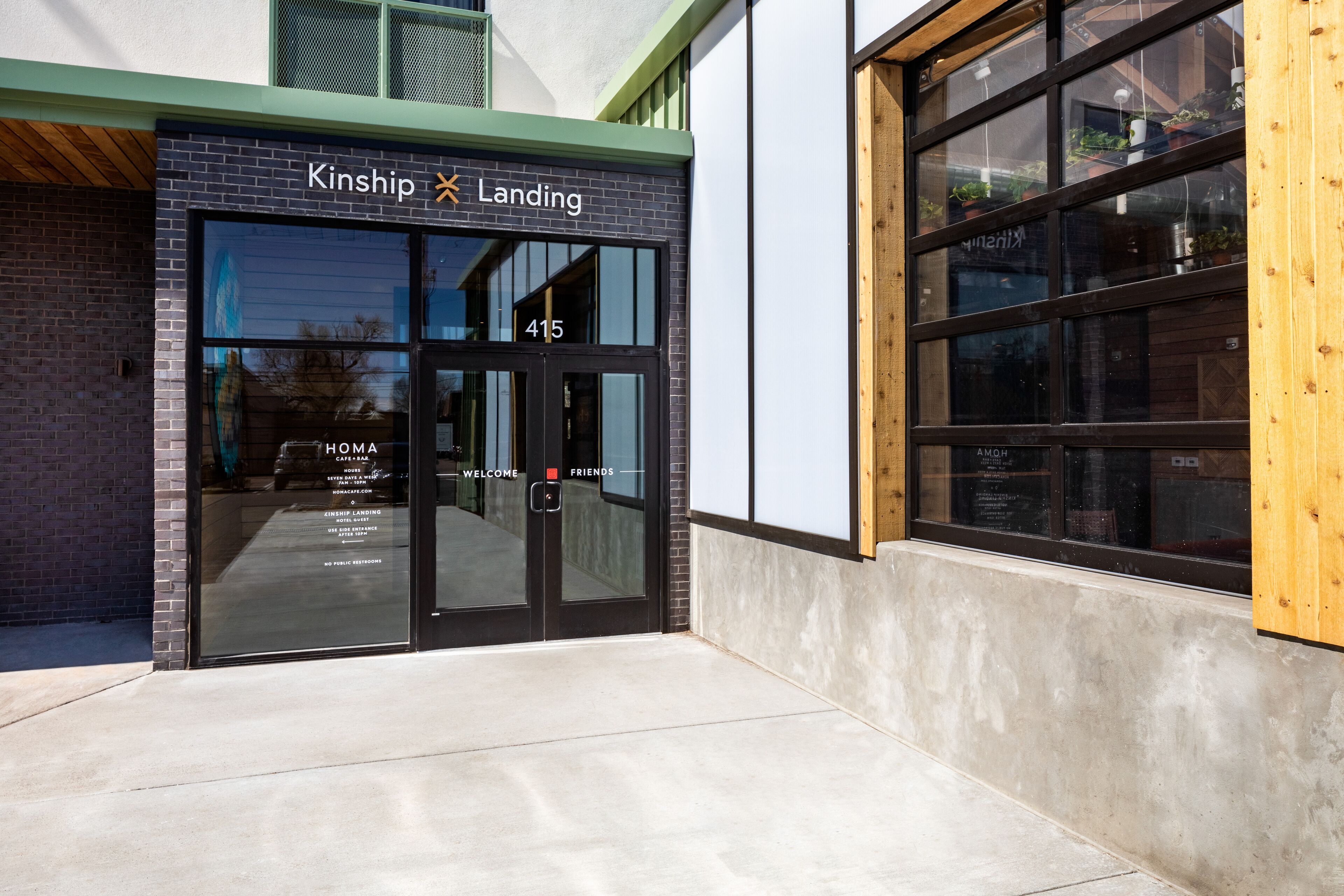 A building entrance with a sign reading "Kinship Landing" and the number 415.