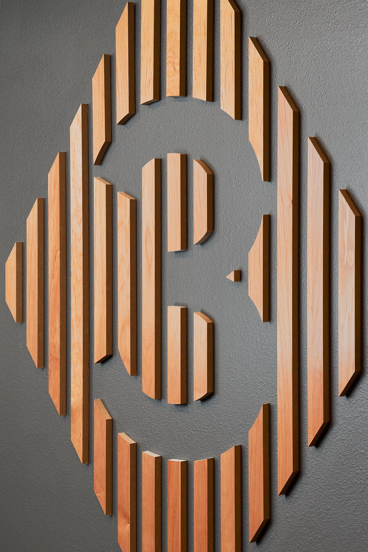Ein geometrisches Holz-Wandbild mit spiralförmigem Muster.