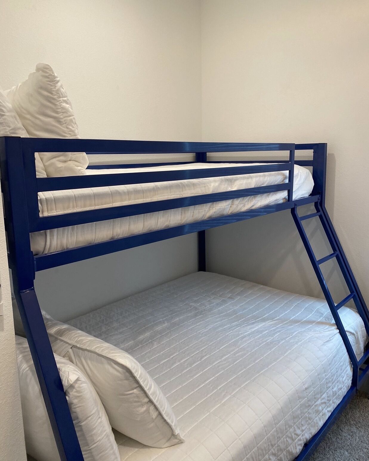 Ein Etagenbett mit zwei Schlafstellen, jeweils mit einer Matratze und Kissen.