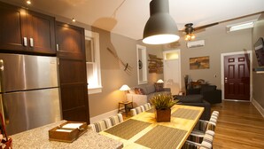 A modern kitchen with a built-in refrigerator, wooden cabinets, and a dining area with a long table and chairs. - Vetehuset-Skorda Quiet Loft with Private Elevator (Lindsborg)