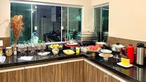 Una cocina con un amplio ventanal, diversos alimentos y utensilios de cocina.