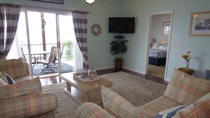 A living room with a sofa set, a television, and a dining area with a table and chairs.