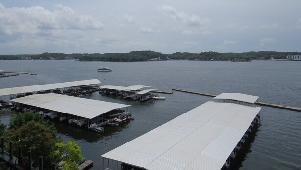 A marina with several covered docks and a boat in the water.