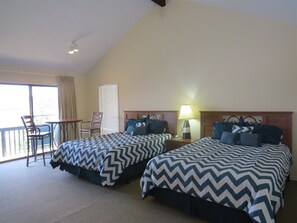 A hotel room with two beds, a desk, and a chair. - 6982 Elbow CAY (Osage Beach)