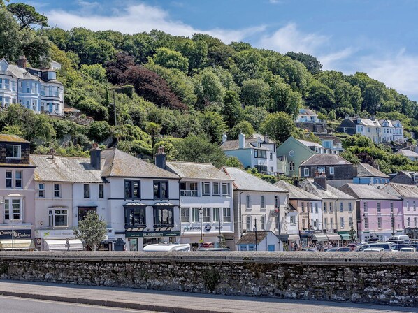 A coastal town with buildings along a stone wall, including a pharmacy and a beauty salon. - 1 bedroom accommodation in Looe (Looe)