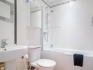 A bathroom with a toilet, sink, and shower. - 1 bedroom accommodation in Looe (Looe)