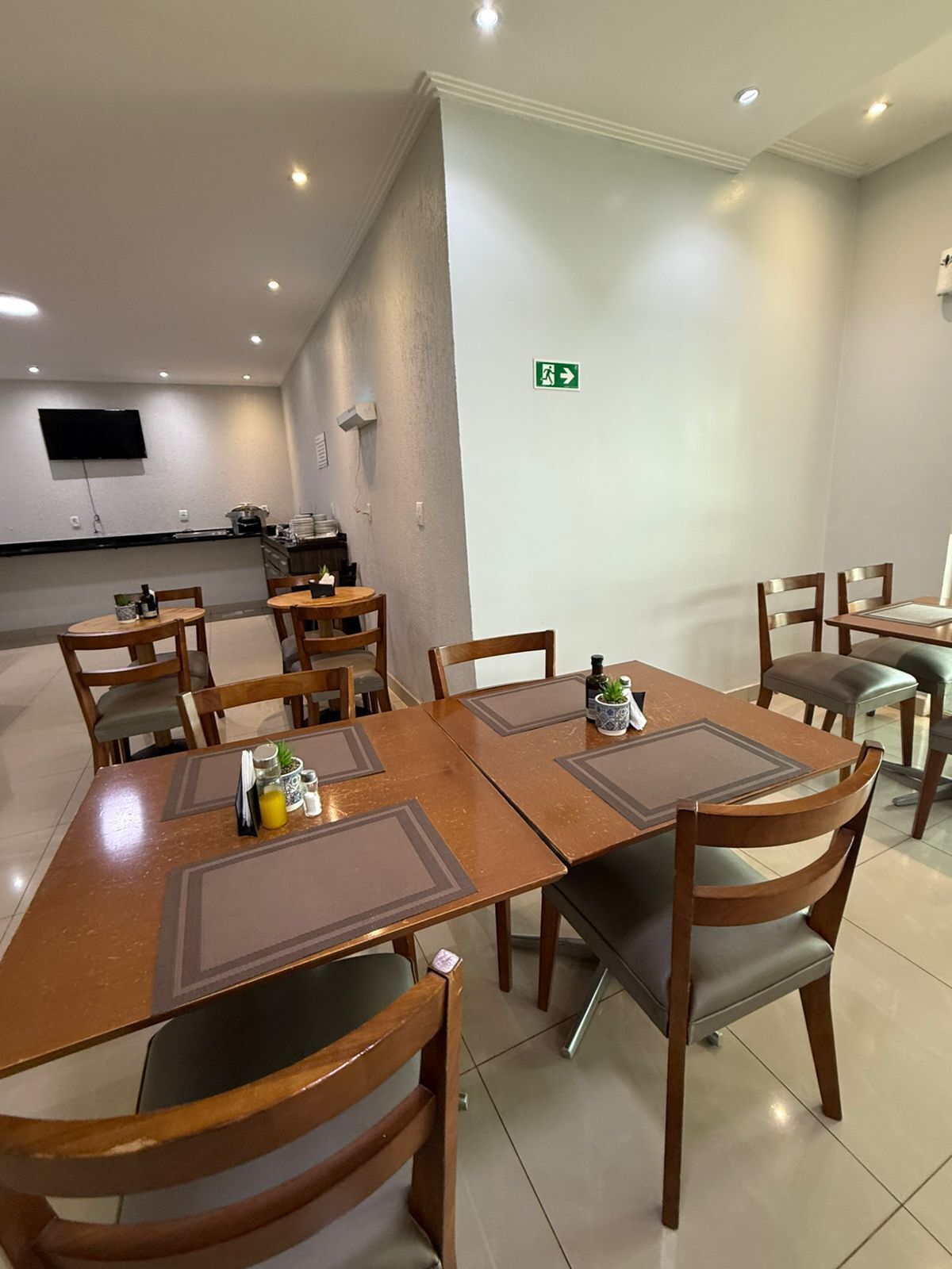 A conference room with a long table, chairs, and a small kitchen area in the background.