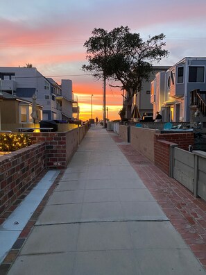 Stroll along the quiet street lined with brick walls and a sidewalk.