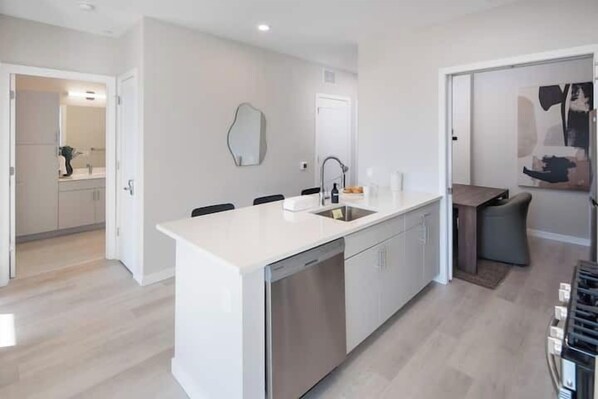 Una cocina moderna con una isla central, electrodomésticos de acero inoxidable y un diseño minimalista.