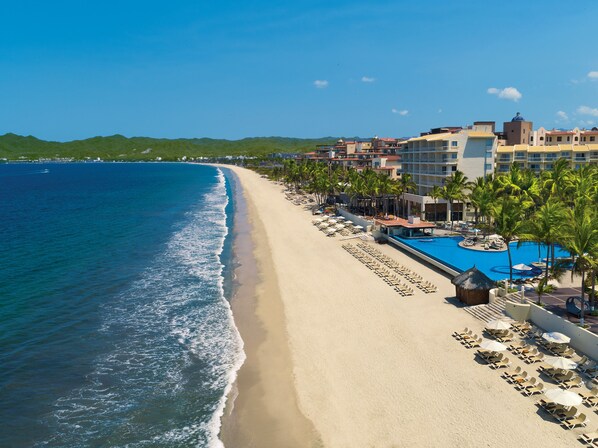 A beach resort with a swimming pool, sun loungers, and a view of the ocean. - Krystal Grand Nuevo Vallarta – All Inclusive (Nuevo Nayarit)