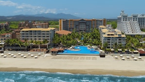 A resort with a large pool, beachfront, and multiple buildings.