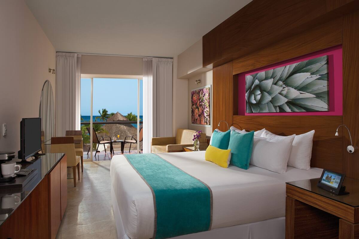 Ein Hotelzimmer mit Bett, Schreibtisch, Sessel und Meerblick.