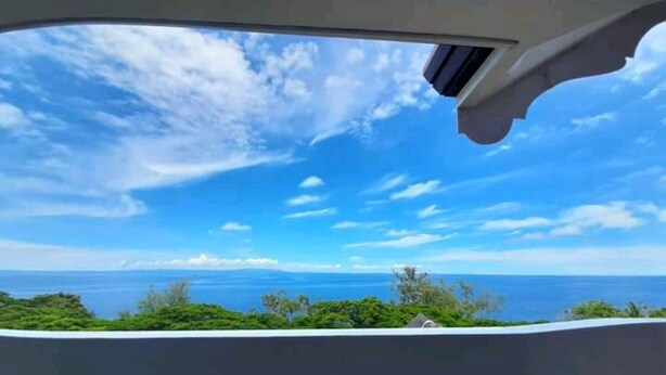 A view from inside a vehicle, looking out at a clear blue sky and ocean. - Canoy's Mansion Apartelle in Dalaguete Cebu (Dalaguete)