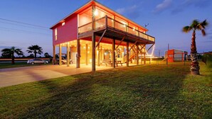 Une maison à deux étages avec un porche couvert, un garage et un terrain de jeux.