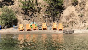 Une plage de sable avec plusieurs chaises en bois et une petite construction en pierre.