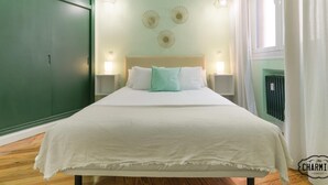 Et hotelværelse med en seng, to sengeborde, en grøn garderobe og en radiator.
