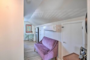 A room with a purple sofa, a white door, and a small wooden table with a vintage telephone. - Spacious Lexington Studio: 2 Miles to Rupp Arena (Lexington)