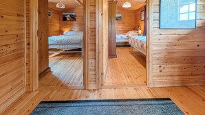 A wooden cabin room with two beds, a ceiling fan, and a framed map on the wall. - 2 bedroom accommodation in Black Isle (Black Isle)