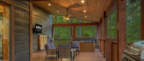 A wooden deck with a grill, chairs, and a sign reading "Book Broken Bow".