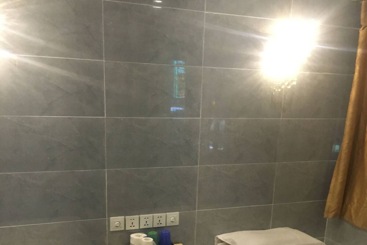Una habitación de hotel con dos camas individuales, una mesita con artículos de aseo y un enchufe.