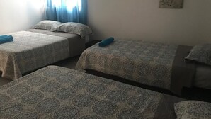 A room with two beds, each with patterned bedding and pillows. - CASA BELLA 2 YOUR PIECE OF PARADISE (san andres isla)