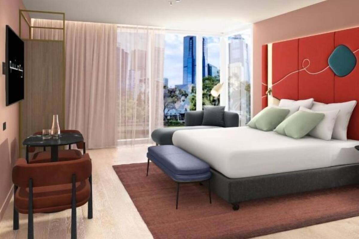 Una habitación de hotel moderna con una cama grande, un escritorio y una silla.