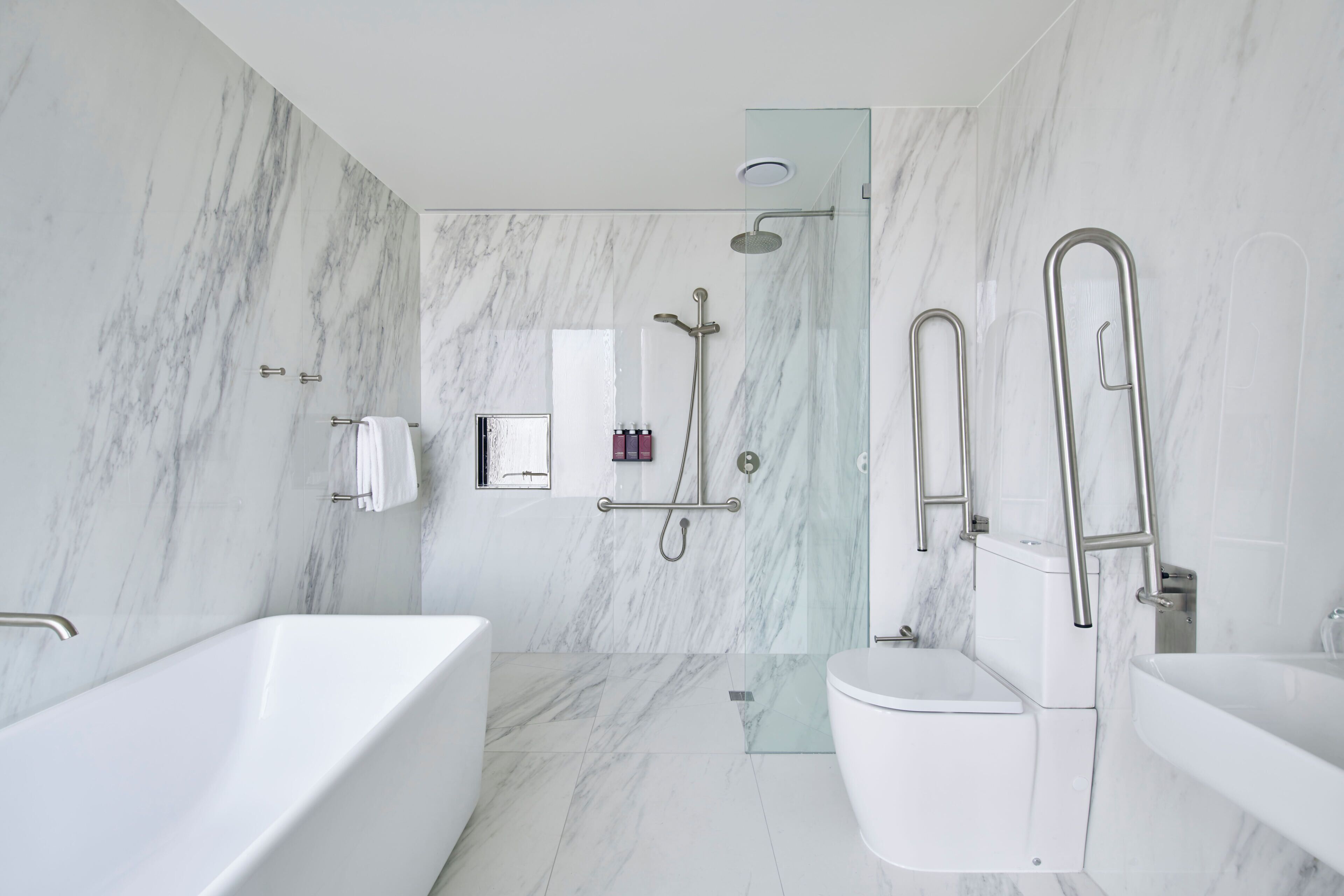 A modern bathroom with a bathtub, toilet, and shower area.