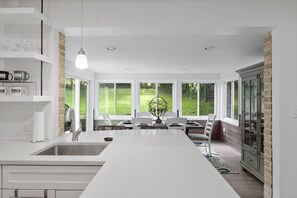 Una cocina moderna con una isla central, ventanas amplias y vistas al exterior.