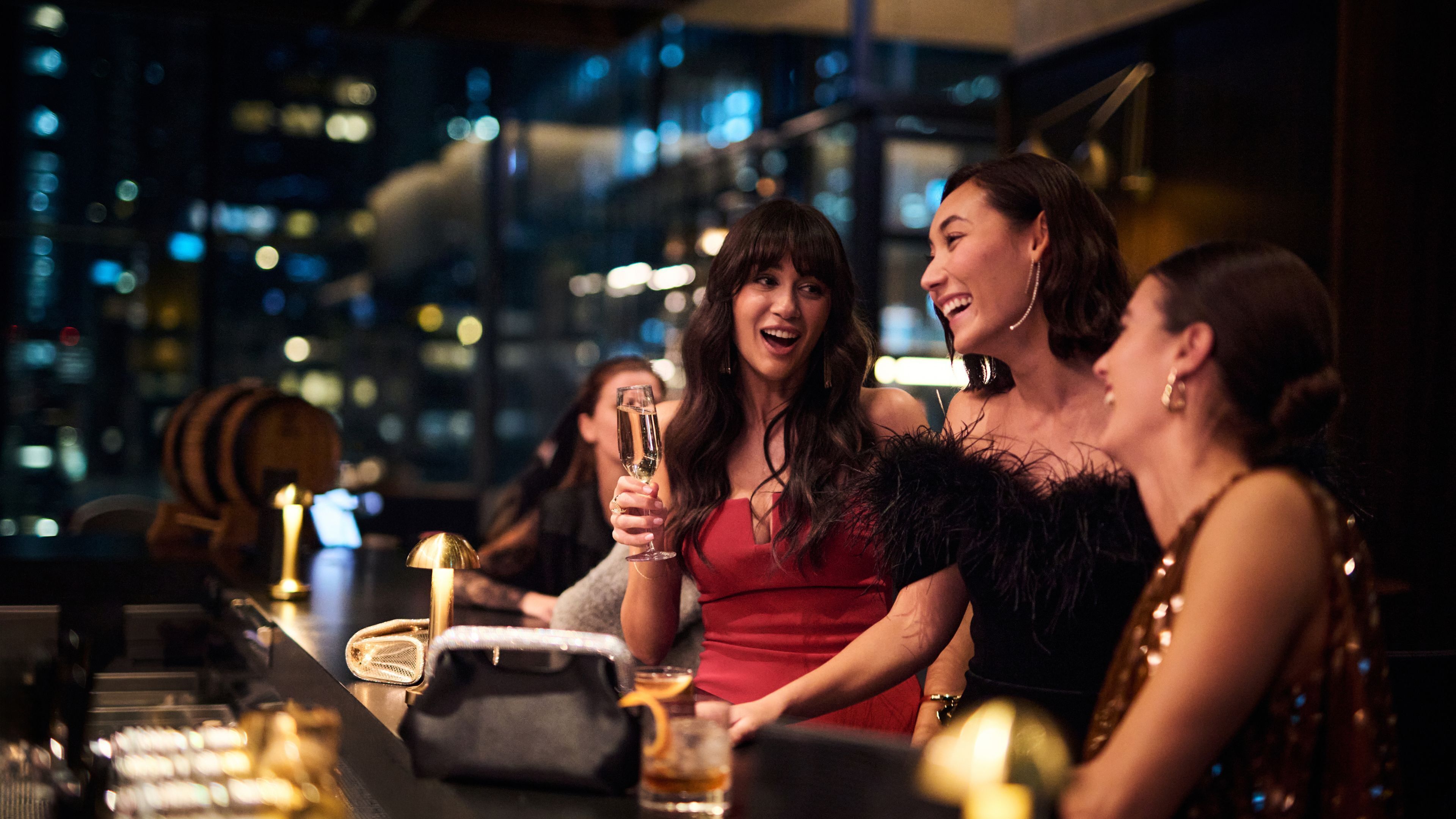 Un grupo de personas en un bar con vistas a la ciudad.