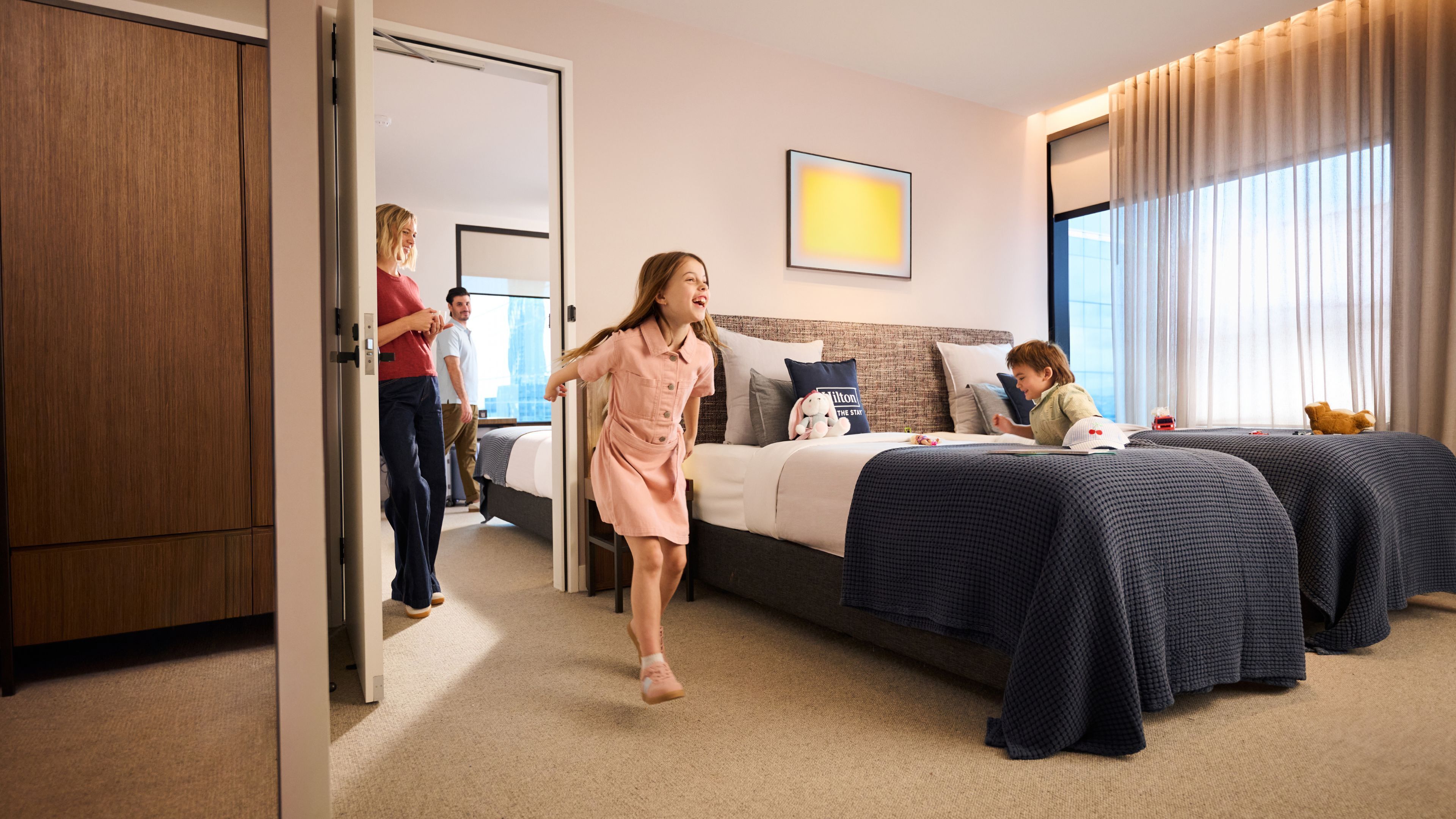 Une chambre d’hôtel avec un lit, un bureau et une fenêtre avec des rideaux.