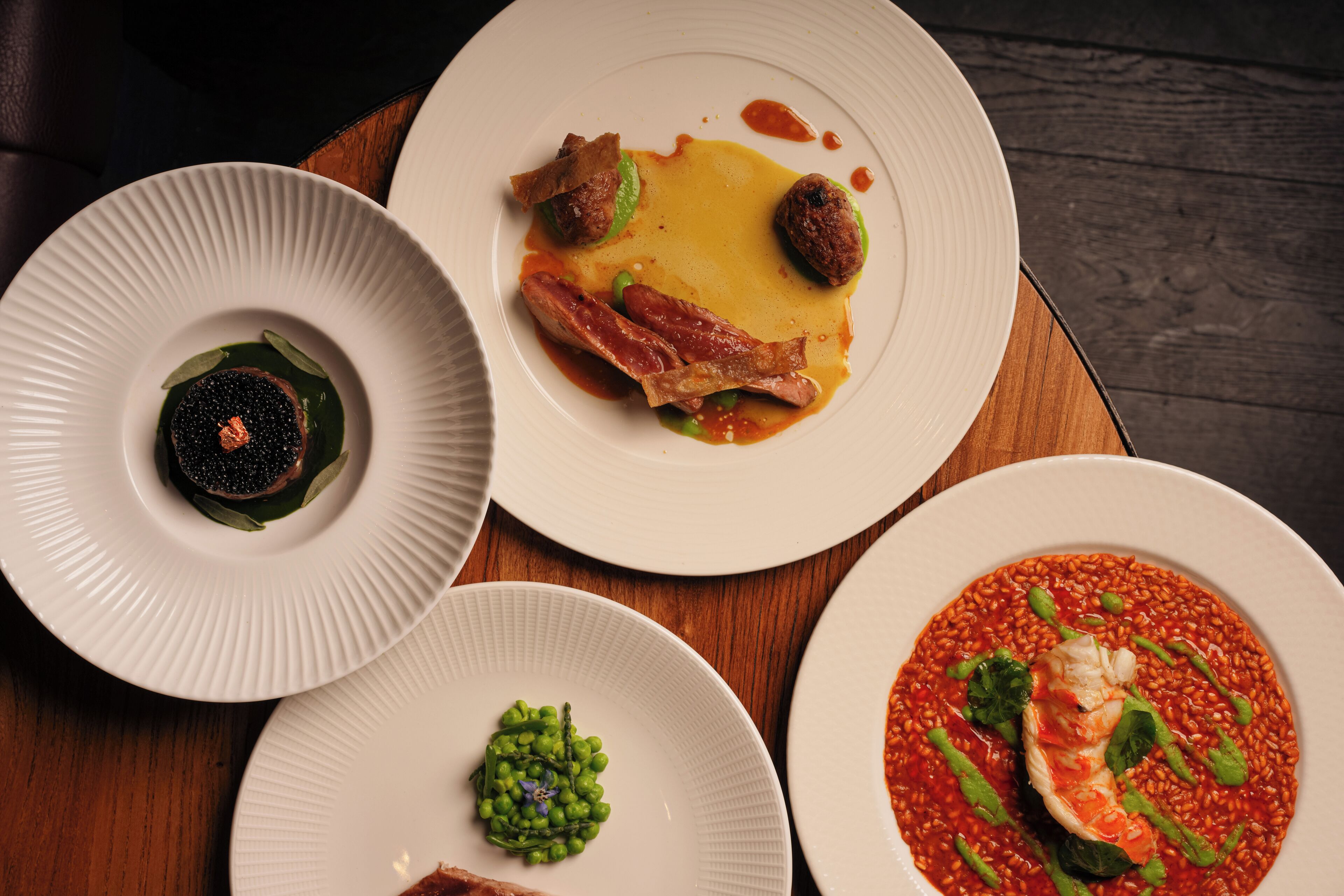 Tres platos de comida sobre una mesa de madera.