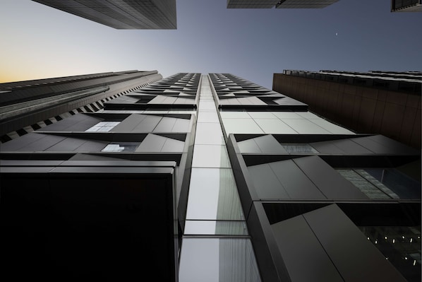 A modern high-rise building with a geometric facade and reflective glass windows. - Next Hotel Melbourne, Curio Collection by Hilton (Melbourne)