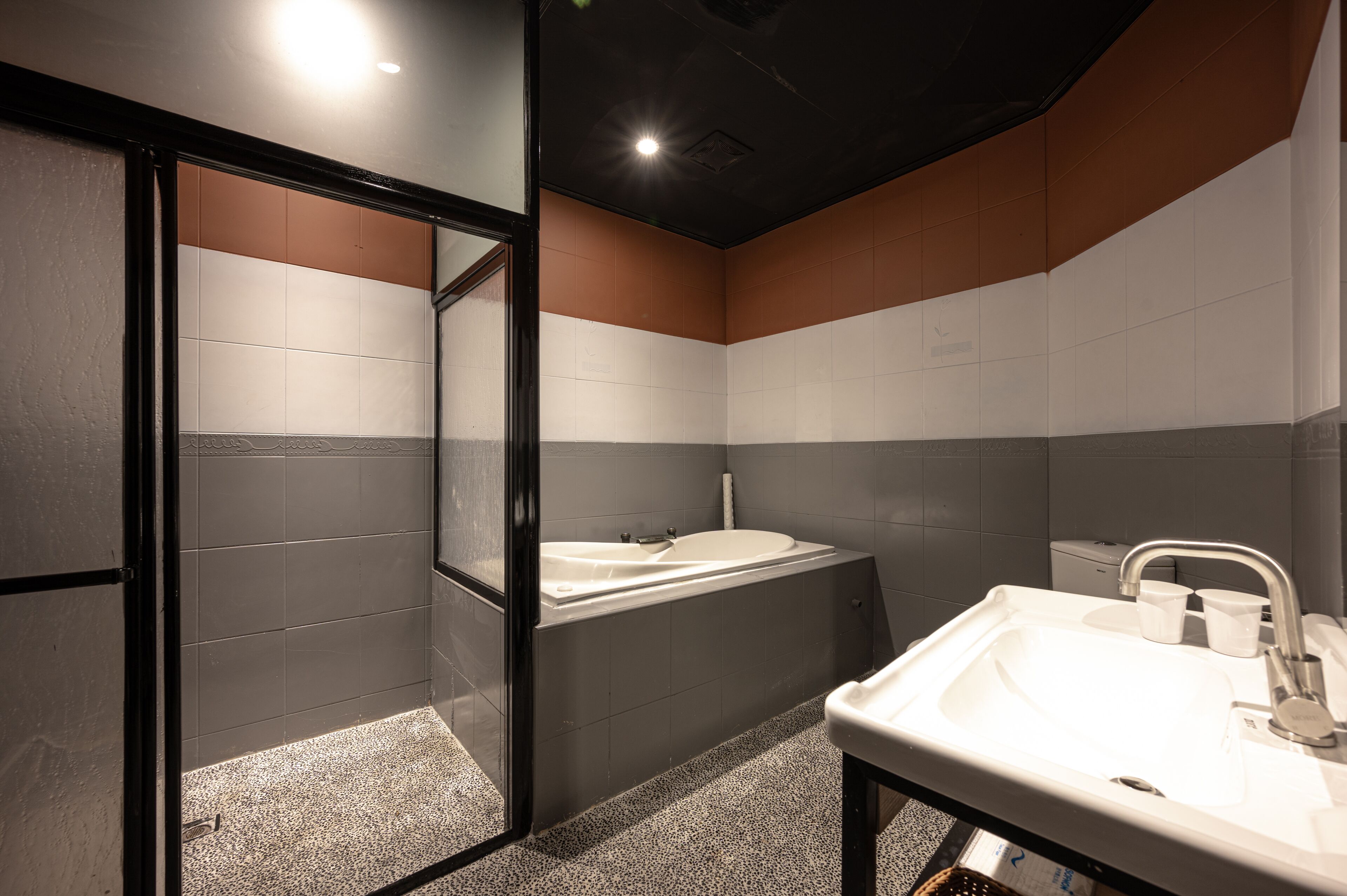 A modern bathroom with a glass-enclosed shower, a freestanding bathtub, and a sink with a mirror.