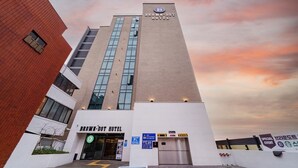 The exterior of the Brown-Dot Hotel with a clear sky and a sunset. - Brown Dot Hotel Busan Sajik Stadium (Busan)
